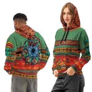 Peut inclure: Un sweat à capuche vert, rouge et orange avec des motifs d'inspiration aztèque. Le sweat à capuche présente un graphisme détaillé d'un serpent et d'autres motifs culturels. La capuche et les manches ont des motifs complexes. Le sweat à capuche est porté par deux personnes.
