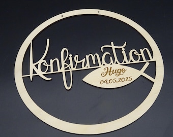 May include: Wooden circle with the word "Confirmation" written in cursive and a fish with the name "Hugo" and the date "04.05.2025" written inside.
