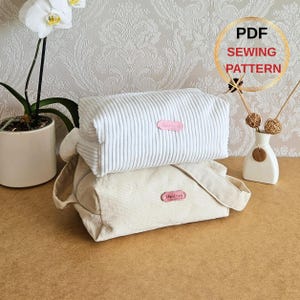 May include: Two corduroy cosmetic bags, one white and one beige, stacked on top of each other. Each bag has a pink label that says "Handmade". The top bag is rectangular, and the bottom bag has a shoulder strap. The image also includes text that says "PDF SEWING PATTERN".