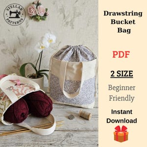 May include: A drawstring bucket bag with a floral pattern and a beige handle. The bag is next to a smaller tote bag filled with burgundy yarn. The image also includes text that says "Drawstring Bucket Bag", "PDF", "2 SIZE", "Beginner Friendly", and "Instant Download".