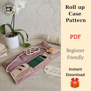 Può includere: Un astuccio arrotolabile rosa polveroso con interno color crema, contenente penne, matite e una piccola busta verde. L'astuccio è legato con un cordoncino color crema. Il testo sull'immagine recita "Roll up Case Pattern" e "Beginner Friendly".