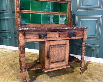 Victorian pine wash stand having a green tiled back, marbled top over two drawers and central cupboard - all resting on turned legs.
