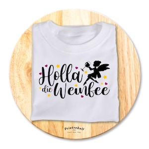 Könnte beinhalten: Weißes T-Shirt mit einer schwarzen Silhouette einer Fee, die ein Glas Wein hält. Der Text "Holla die Weinfée" ist in Schwarz auf das Shirt gedruckt.