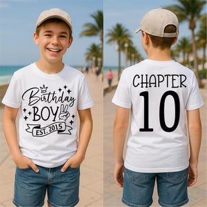 Könnte beinhalten: Zwei weiße T-Shirts mit schwarzem Text. Das erste Shirt sagt "Birthday Boy Est. 2015" mit einer Krone und Sternen. Das zweite Shirt sagt "Chapter 10".