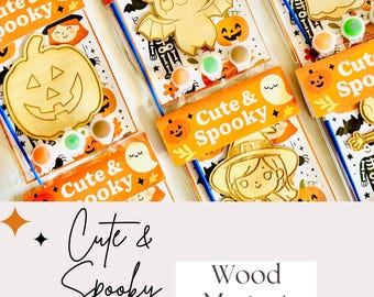 May include: A selection of Halloween-themed wood magnet kits. Each kit contains a wooden cutout of a pumpkin, bat, ghost, witch, or skeleton, paint pots, and a paintbrush. The kits are packaged with orange and white labels that read "Cute & Spooky."