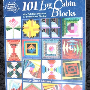 May include: A blue instructional book titled 101 Log Cabin Blocks by Linda Causee, featuring full-size patterns for foundation piecing. The cover displays a grid of sixteen colorful, geometric quilt block designs in various patterns and shapes.