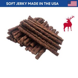 May include: A pile of dark brown jerky sticks. The text "SOFT JERKY MADE IN THE USA" is at the top, with an American flag. A red deer silhouette is on the right.