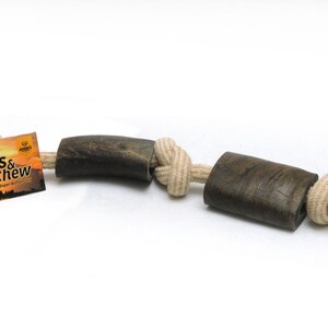 May include: A brown antler dog chew toy with a natural rope attached. The toy is tied in a knot and has the words "Toss & Chew" on the label.