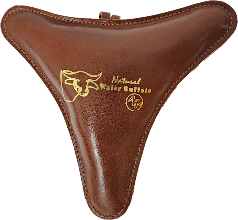 May include: A brown leather ocarina with a gold design of a water buffalo and the text "Natural Water Buffalo" and "A/P".