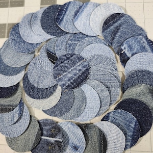 May include: Circular denim patchwork design. The design is composed of numerous denim circles in varying shades of blue, arranged in a spiral pattern. The denim pieces are cut from different parts of jeans, showcasing diverse textures and washes.