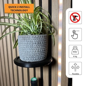 May include: A black shelf with a gray pot plant on it. The shelf is attached to a wall with a wood paneling design. The shelf is labeled "Quick 2 Install Technology". There are four icons on the right side of the image: a drill with a red circle and a diagonal line through it, a hand with a finger pressing a button labeled "click!", a bag with "KG" and "6 kg" written on it, and an arrow pointing in four directions labeled "flexible".