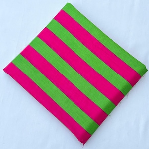 May include: A square piece of fabric featuring a repeating pattern of bold, diagonal stripes in vibrant lime green and hot pink. The textile is folded neatly, displaying a consistent width for each colored stripe across the entire surface area.