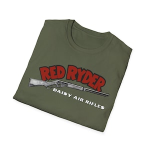 May include: An olive green t-shirt with the words "Red Ryder" in red above a detailed illustration of a Daisy air rifle. The text "Daisy Air Rifles" is printed in white below the rifle.