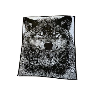 May include: Black and white throw blanket with a wolf's face printed on it.