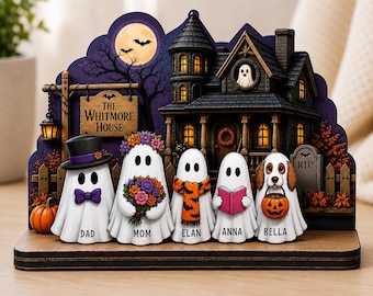 Könnte beinhalten: Eine Halloween-Dekoration aus Holz mit einem Spukhaus-Hintergrund, Vollmond und einem Schild mit der Aufschrift The Whitmore House. Fünf Geisterfiguren mit den Namen Dad, Mom, Elan, Anna und Bella tragen Accessoires wie Zylinder, Blumen, Schal, Buch und einen Kürbiseimer.