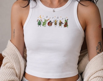 Könnte beinhalten: Ein weißes ärmelloses Tanktop mit einem Grafikdruck einer Gruppe von Cartoon-Insekten, die Musikinstrumente spielen, darunter ein Käfer, eine Heuschrecke, ein Marienkäfer und Bienen, begleitet von kleinen Noten und Sternen über den Figuren.