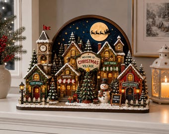 Könnte beinhalten: Ein beleuchtetes Weihnachtsdorf mit Uhrturm, Spielzeugladen, Bäckerei, Geschenkeladen und Postamt. Die Szene zeigt einen zentralen Weihnachtsbaum, einen Schneemann und ein Schild mit der Aufschrift Welcome to Christmas Village bei Nacht.