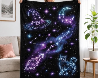 Könnte beinhalten: Eine schwarze Fleecedecke mit einem lebendigen himmlischen Druck, der einen Hexenhut, eine Mondsichel, einen Besen und eine Katze zeigt, die alle aus leuchtenden blauen und violetten Sternbildern vor einem dunklen Nebelhintergrund bestehen.