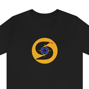 May include: Black t-shirt with a yellow circle containing a black snake wrapped around a blue globe with a red target in the center.