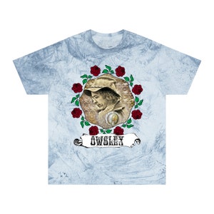 May include: Light blue tie-dye t-shirt featuring a portrait surrounded by red roses and green leaves. The portrait is of a man wearing a hat and a badge. The word "OWSLEY" is printed on a banner below the portrait.
