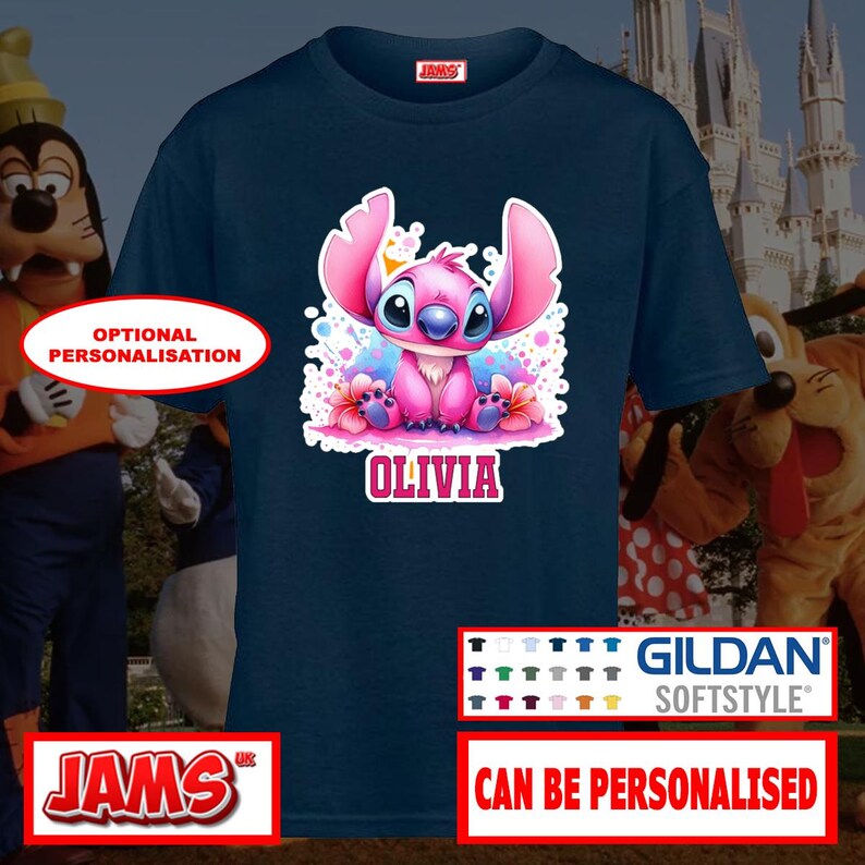 May include: Navy blue Gildan Softstyle t-shirt featuring a colorful graphic of a pink cartoon character with the name "Olivia". The shirt has a crew neck and short sleeves. The text "Can Be Personalised" is also visible.