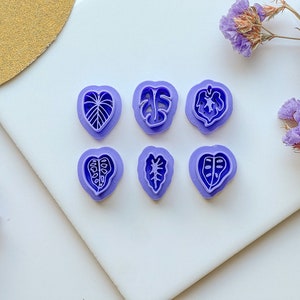 May include: Set of six purple plastic leaf-shaped cookie cutters.