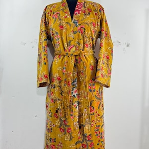 May include: Mustard yellow floral print robe with a matching belt. The robe features a V-neck and long sleeves. The floral pattern includes red, pink, and green accents. The robe is displayed on a mannequin.