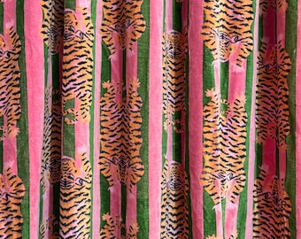 May include: A fabric curtain featuring a repeating pattern of orange and black tigers oriented vertically. The tigers are positioned within alternating vertical stripes of solid pink and solid green, creating a vibrant, multi-coloured textile design.