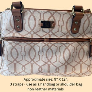 May include: White and tan handbag with a geometric pattern, brown accents, and multiple straps. The bag has a zippered front pocket and brown leather-like handles. Approximate size: 9" x 12".