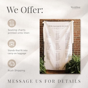 May include: A white linen wedding seating chart hanging on a black metal frame. The fabric features the text "OUR FAVORITE PEOPLE" and "we saved you a seat" followed by lists of names organized by table numbers. The chart is tied to the frame.