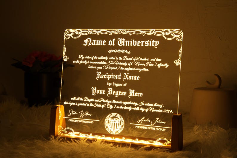 K&ouml;nnte beinhalten: Eine beleuchtete Acryl-Plakette mit goldenem Rahmen, auf der ein Abschlusszeugnis abgebildet ist. Der Text lautet "Name of University" und "Recipient Name" mit dem Abschluss "Your Degree Here". Das Zertifikat ist datiert auf "November 2024".