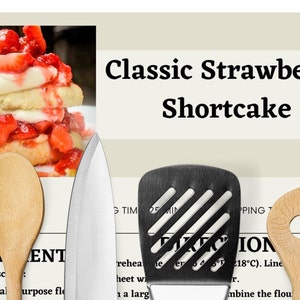 May include: A recipe card for Classic Strawberry Shortcake with a photo of a strawberry shortcake dessert, a whisk, a wooden spoon, a chef's knife, a spatula, a wooden spoon with a hole in the center, and a fork.