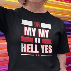 Könnte beinhalten: Ein schwarzes T-Shirt mit weißem und rotem Text, der "Oh My My Oh Hell Yes" lautet. Das Model trägt das T-Shirt mit einem schwarzen Lederrock.