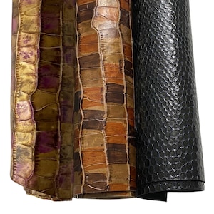 Peut inclure: Trois rouleaux de tissu en simili cuir. Le premier rouleau est un motif de crocodile doré et violet, le deuxième rouleau est un motif de crocodile brun et orange, et le troisième rouleau est un motif de peau de serpent noir.