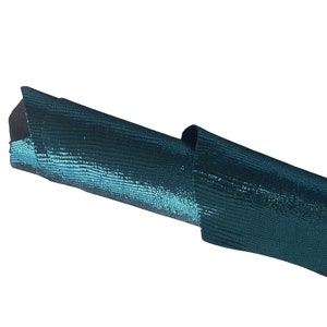 May include: A teal blue textured fabric with a subtle shimmer. The fabric is rolled up and the texture is visible.