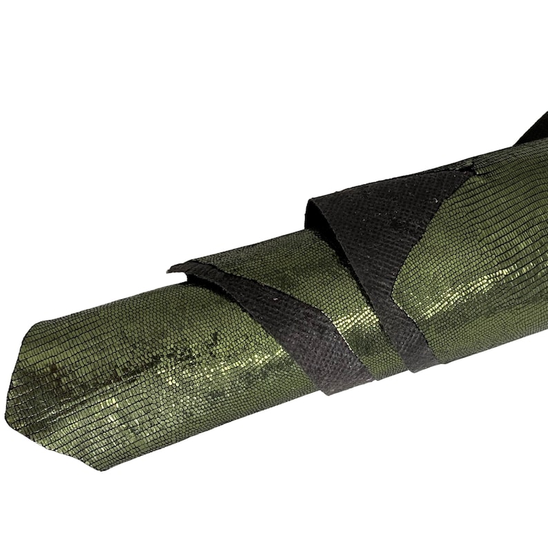 May include: A rolled up piece of green and black textured leather. The leather has a shiny, almost metallic finish.