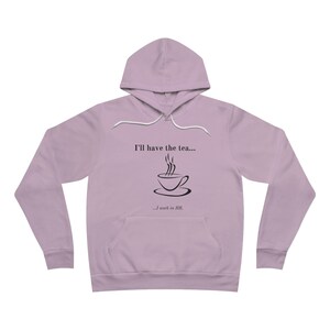 Peut inclure: Un sweat à capuche de couleur lavande avec un graphique noir d'une tasse de thé et le texte "I'll have the tea...  ...I work in HR."