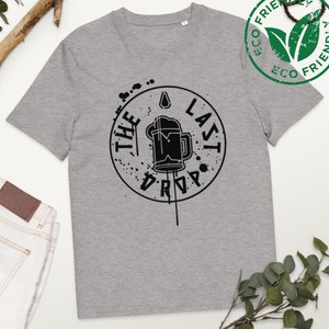 Puede incluir: Una camiseta gris con un gráfico negro de una jarra de cerveza con el texto "The Last Drop" en un círculo.