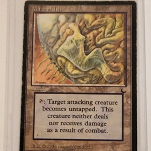 May include: A Magic: The Gathering card called "Maze of Ith". It is a land card with a brown, green, and white illustration of a maze. The card text reads: "Target attacking creature becomes untapped. This creature neither deals nor receives damage as a result of combat."