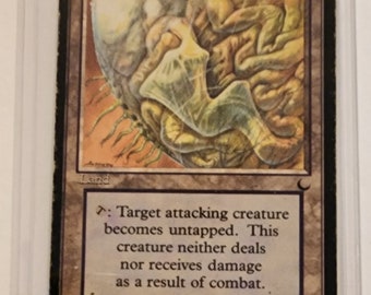 Könnte beinhalten: Eine Magic: The Gathering Karte namens "Irrgarten von Ith". Es ist eine Landkarte mit einer braunen, grünen und weißen Illustration eines Labyrinths. Der Kartentext lautet: "Die angreifende Kreatur, die du wählst, wird ungetippt. Diese Kreatur fügt keinen Schaden zu und erhält keinen Schaden im Kampf."