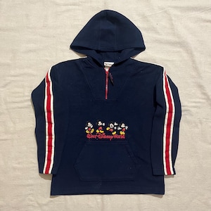 May include: A navy blue hooded sweatshirt with red and white stripes on the sleeves. The sweatshirt has a half-zip closure and a kangaroo pocket. It features an embroidered image of Mickey Mouse and the text "Walt Disney World".