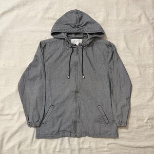 Op de afbeelding: Een zwart-wit geblokt hooded jack met een ritssluiting. Het jack heeft twee zakken en een capuchon met trekkoord.