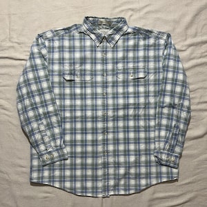 May include: A long-sleeved, button-down shirt with a plaid pattern in shades of blue, green, and white. The shirt has two chest pockets and a button-down collar. The brand label is visible at the collar.