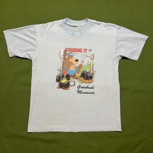 Vintage jaren 80/90 Roughing It Bear Greenbush Minnesota Camping wandelen bos cartoon grafisch T-shirt blauw groot/XL