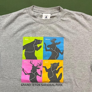 Pode incluir: Camiseta cinza com um gráfico de quatro animais, um urso, um alce, um veado e um lobo, cada um com fones de ouvido e dançando. O texto "iBear", "iMoose", "iDeer" e "iWolf" está acima de cada animal. O texto "GRAND TETON NATIONAL PARK" está na parte inferior do gráfico.