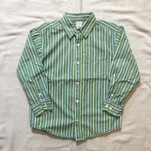 May include: Green and white striped button-down shirt with a chest pocket. The long-sleeved shirt has a classic collar and buttoned cuffs. The shirt is made of a lightweight fabric.