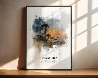 Può includere: Stampa artistica incorniciata con un paesaggio ad acquerello della Namibia, Africa meridionale. L'opera presenta un tramonto con alberi in silhouette e un cielo vibrante. La stampa è in una cornice nera e poggia su una superficie di legno.