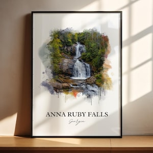Könnte beinhalten: Ein gerahmter Kunstdruck mit einem Aquarellgemälde der Anna Ruby Falls in Georgia. Das Kunstwerk zeigt einen Wasserfall, der von grünen Bäumen und Felsen umgeben ist. Der Text "ANNA RUBY FALLS Georgia" ist unten aufgedruckt.