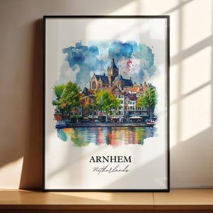 Op de afbeelding: Een aquarel schilderij van een stadsgezicht met een kerktoren en gebouwen langs een kanaal. Het schilderij heeft een blauw, groen en bruin kleurenschema. De tekst "ARNHEM Nederland" staat onderaan het schilderij.