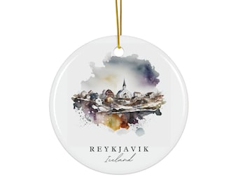 May include: A round white ceramic ornament featuring a watercolor illustration of a cityscape with a central church spire. The design includes splashes of purple, blue, and orange. The text REYKJAVIK Iceland is printed in black below the illustration.